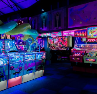An indoor arcade filled with vibrant gaming machines lit with neon blue and pink lights. The scene includes various arcade games with flashing screens and colorful displays, and a large overhead structure resembling a green snake. The background shows illuminated signs and themed decor, contributing to an immersive entertainment atmosphere.