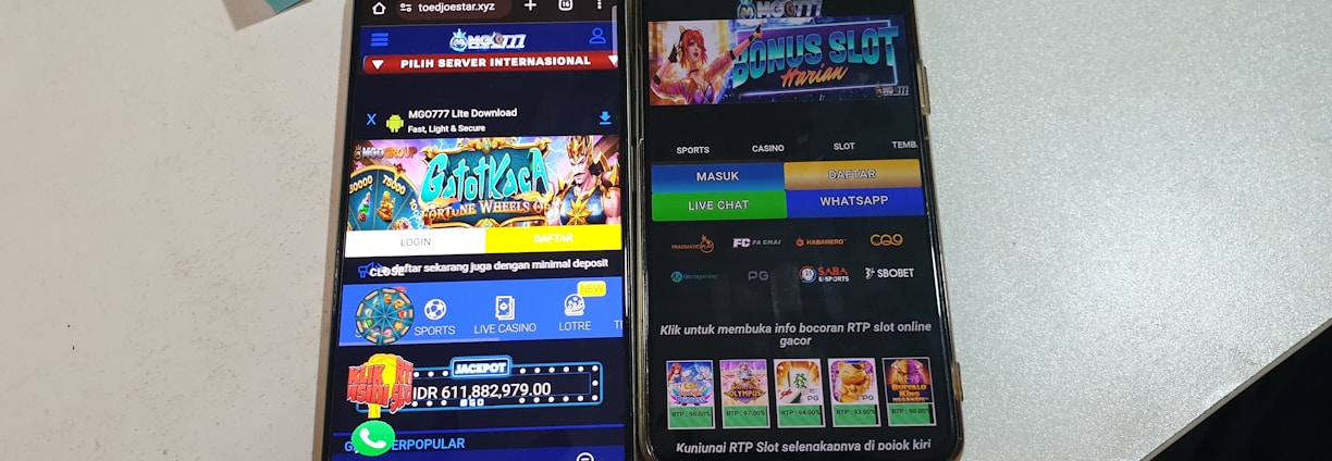 Two smartphones are displayed on a white surface, both showing gambling websites with colorful graphics, text, and various options for logging in and accessing games. The screens are bright and filled with promotional content related to casino and slot games.